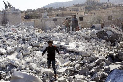 CLICK IMAGE for slideshow: Residents inspect damaged buildings in what activists say was a U.S. strike, in Kfredrian, Idlib province September 23, 2014. (REUTERS/Abdalghne Karoof)